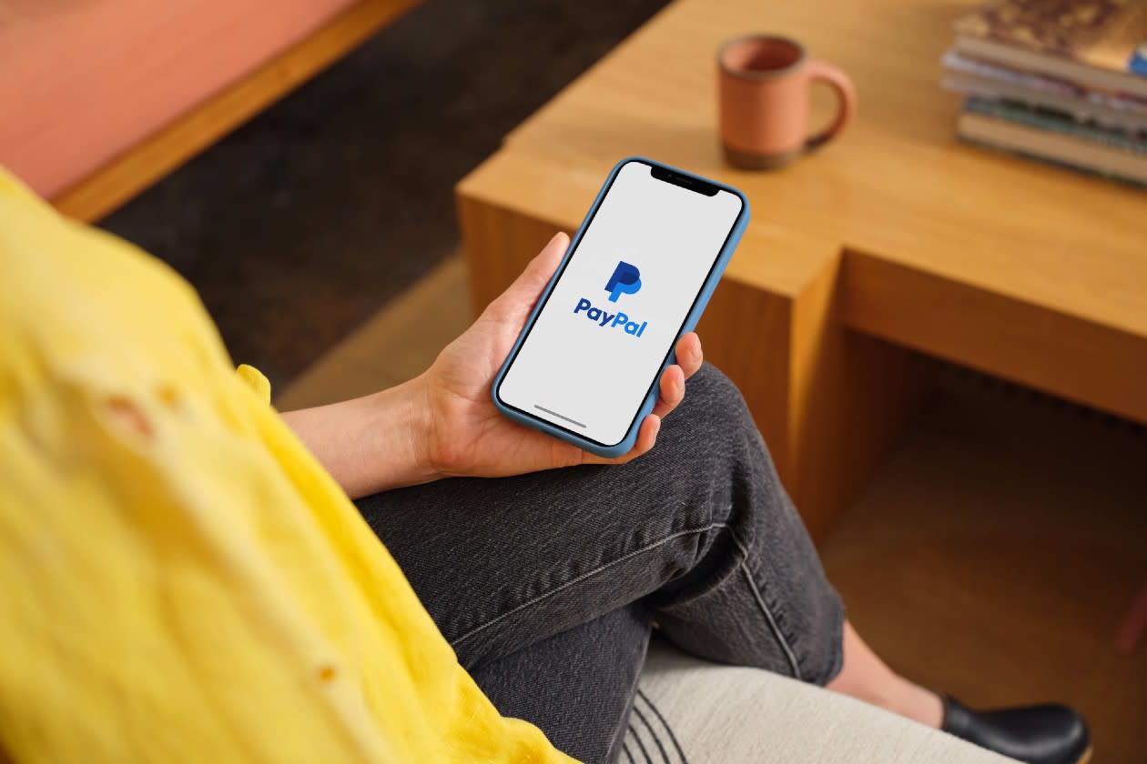 Payment Gateways for Selling Digital Files, Software and Top-Ups Game 2 A paypal user reviewing the app on their phone